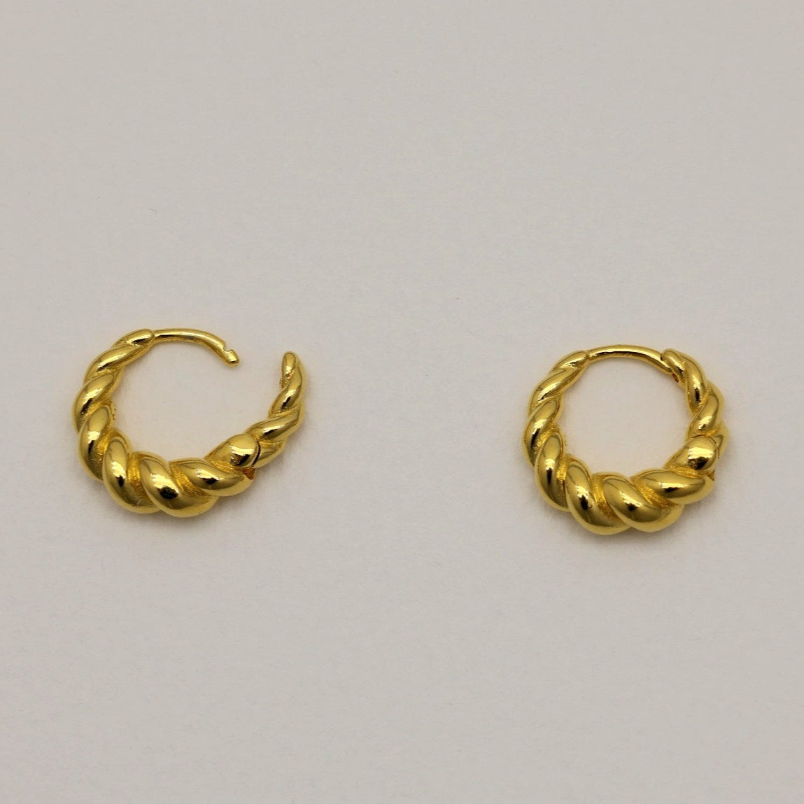 Matte gold vermeil rope twist mini hoop earrings with hinge closure, displayed on neutral background.