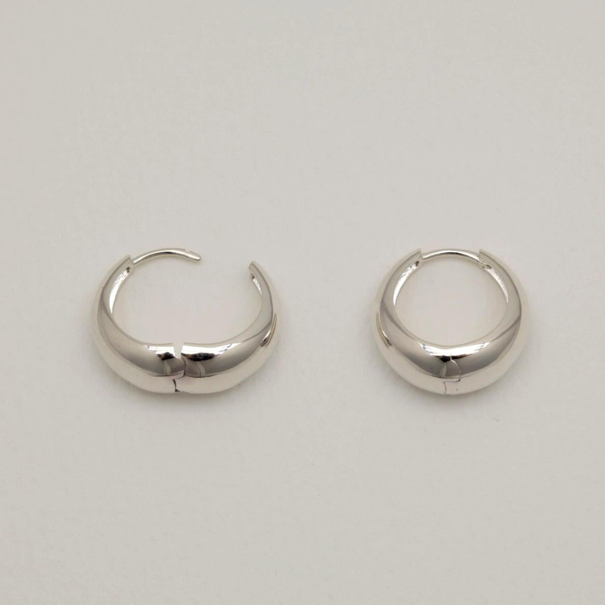 Pair of silver hoop earrings on a light gray background