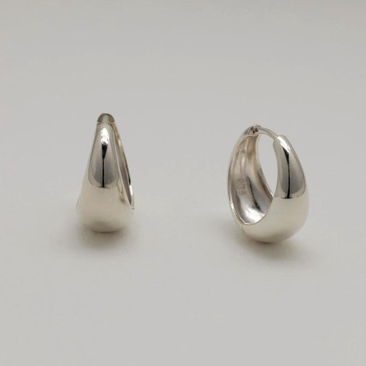 Two silver hoop earrings on a light gray background