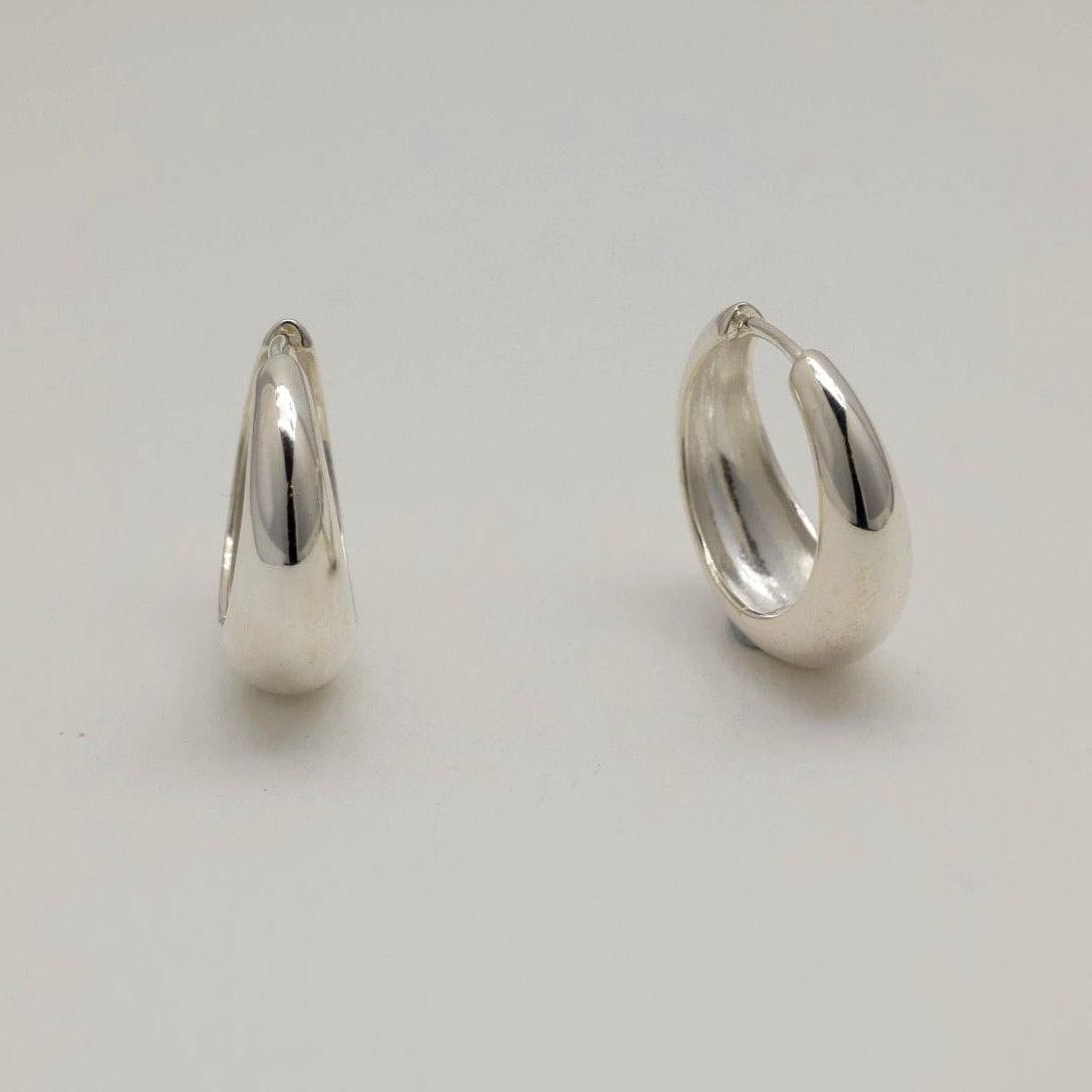 Pair of silver hoop earrings on a light gray background