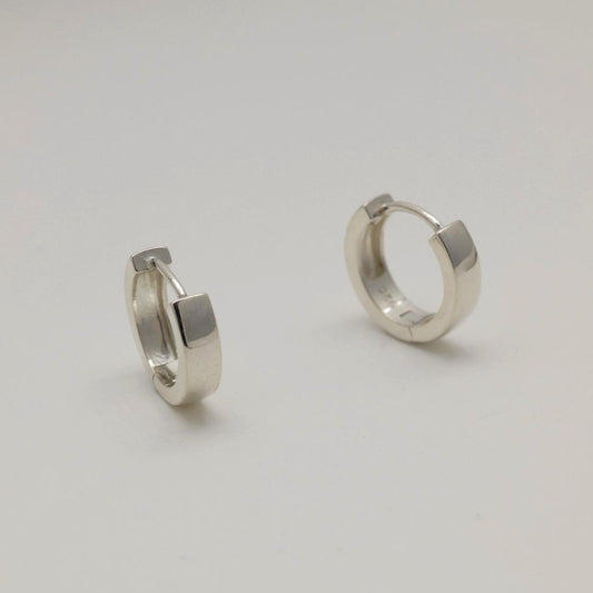Pair of silver hoop earrings on a light gray background