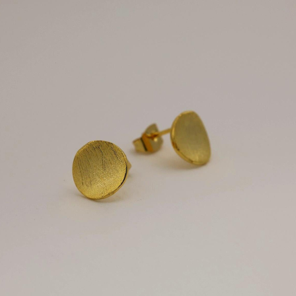 Matte gold vermeil disc stud earrings on white background