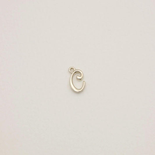 Sterling silver initial pendant with softly polished finish, photographed on neutral background.