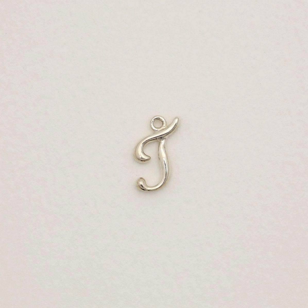 Sterling silver initial pendant with softly polished finish, photographed on neutral background.