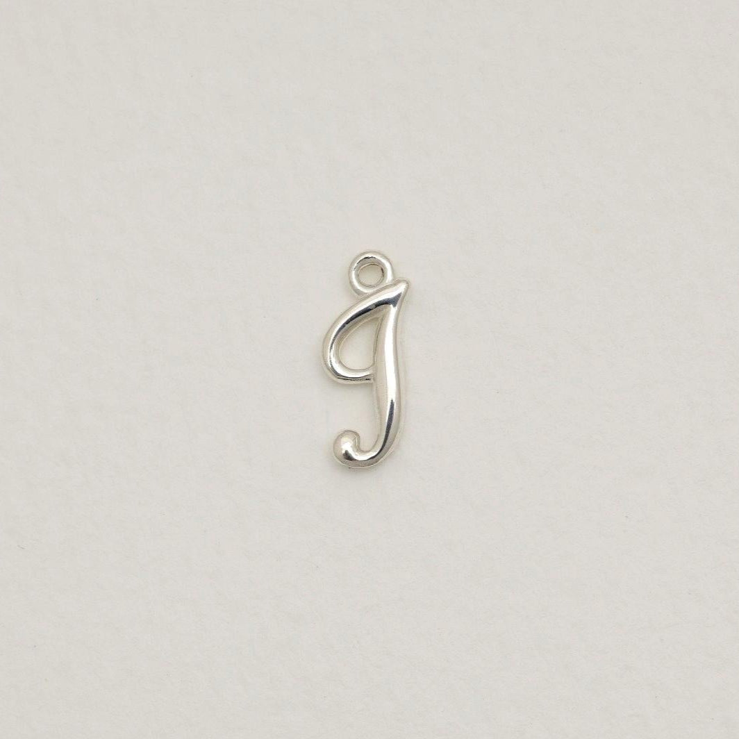 Sterling silver initial pendant with softly polished finish, photographed on neutral background.