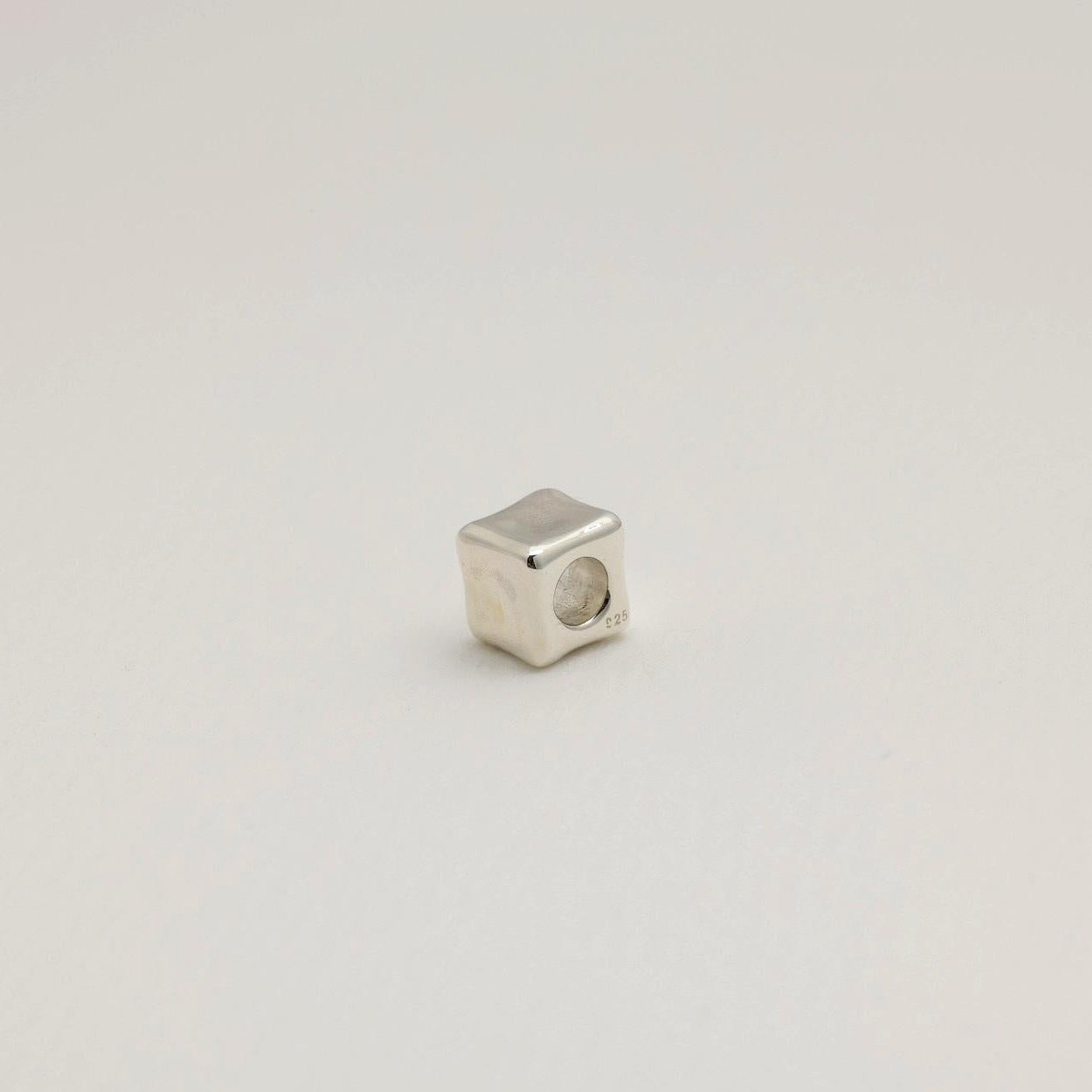 Sculptural cube pendant in polished sterling silver with smooth, contoured edges. Minimal and modern design, made in Korea.