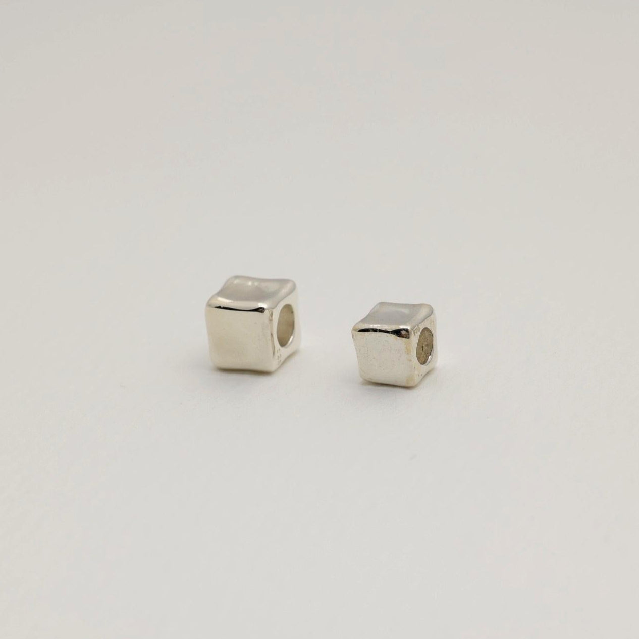 Sculptural cube pendant in polished sterling silver with smooth, contoured edges. Minimal and modern design, made in Korea.