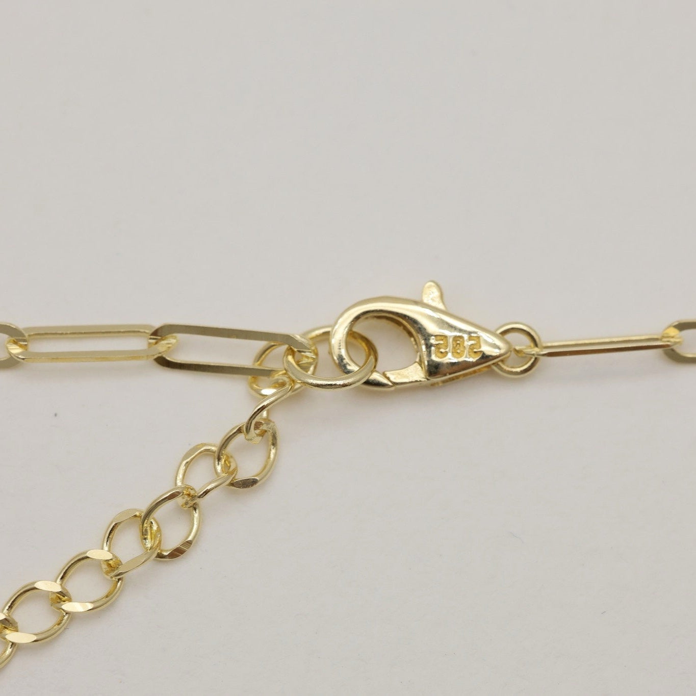 Macro shot of lobster clasp on 14K gold Inès chain bracelet marked 585.