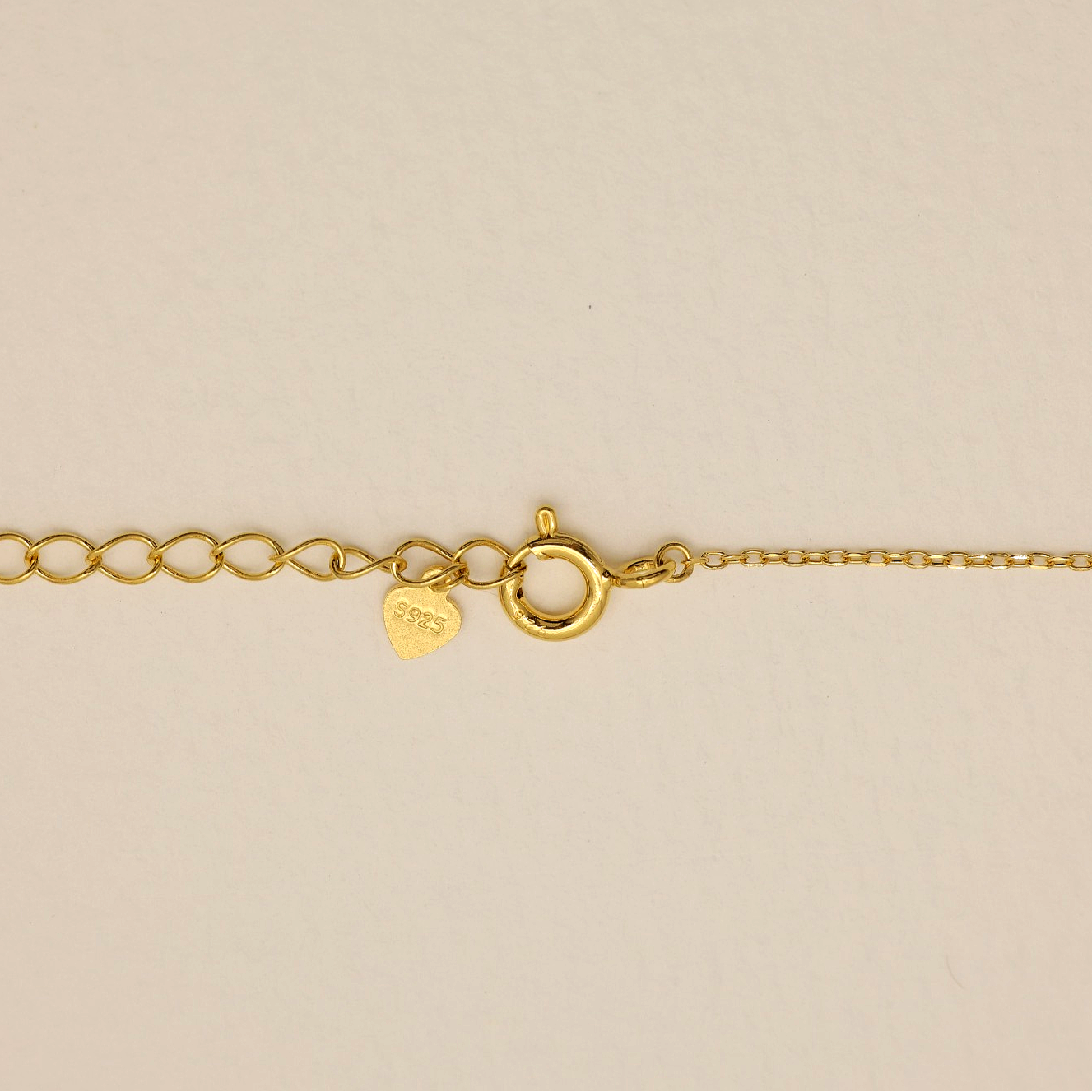 Gold vermeil lobster clasp and extension links of the Léontine Necklace on a white background.