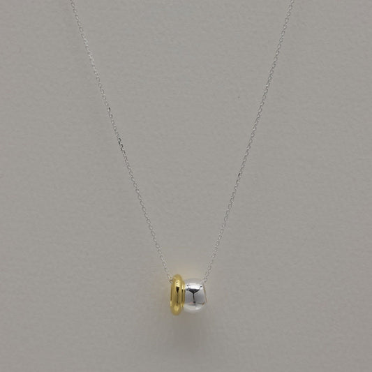 Front view of the Léontine Necklace styled in a soft curve, highlighting the contrast between the gold and silver tones.