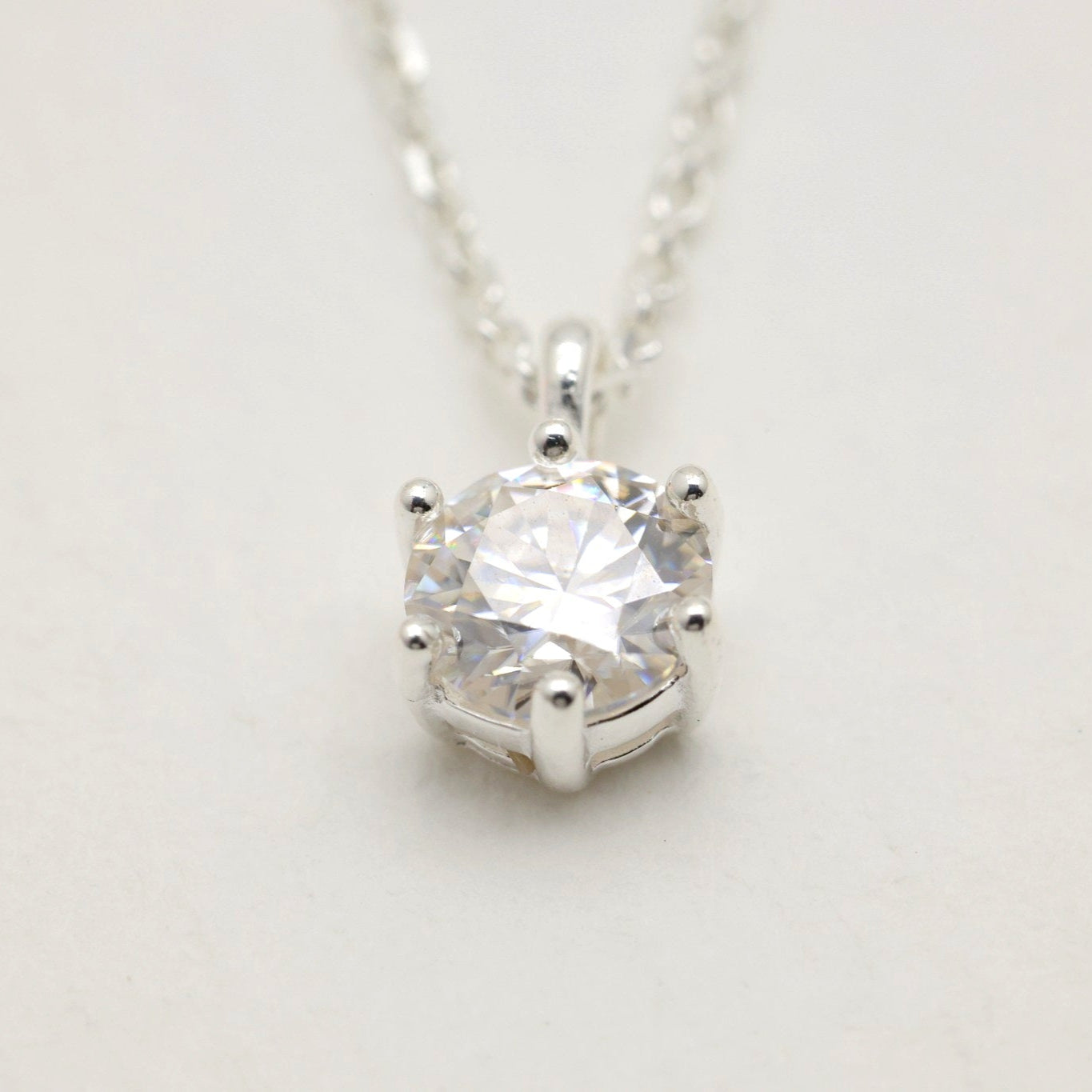 Close-up of the 5-carat moissanite in a six-prong setting on the Lucille Grande Necklace.