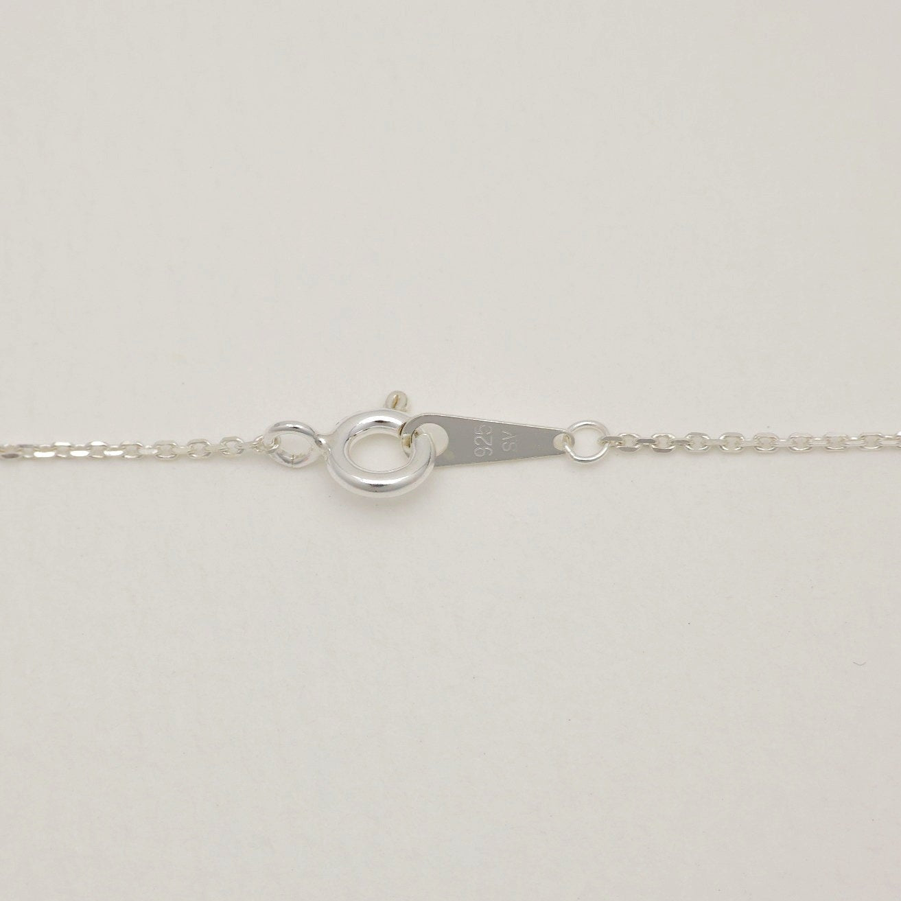 Detail of the spring clasp and silver hallmark tag on the Lucille Grande Necklace.