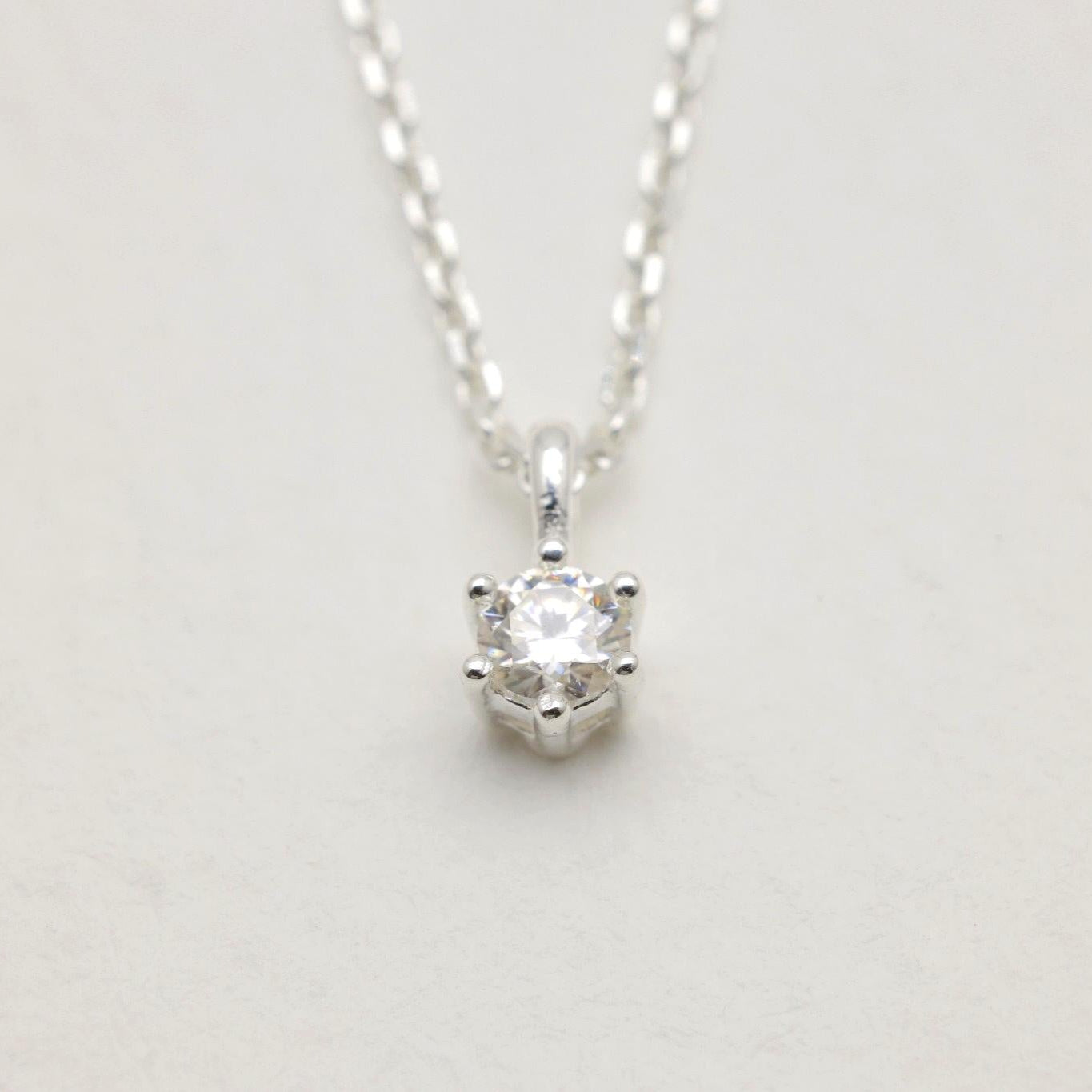 Close-up of the moissanite pendant with six-prong setting on the Lucille Necklace.