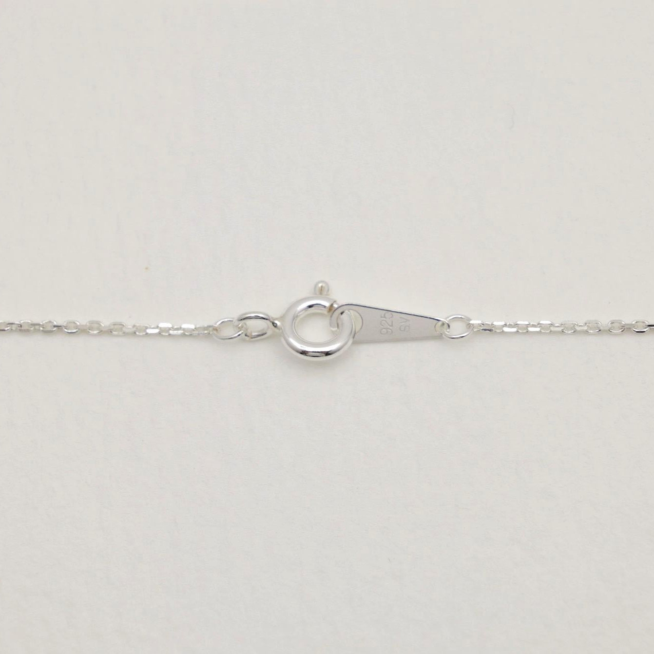 Detail shot of the spring clasp and hallmark tag on the Lucille Necklace in sterling silver.