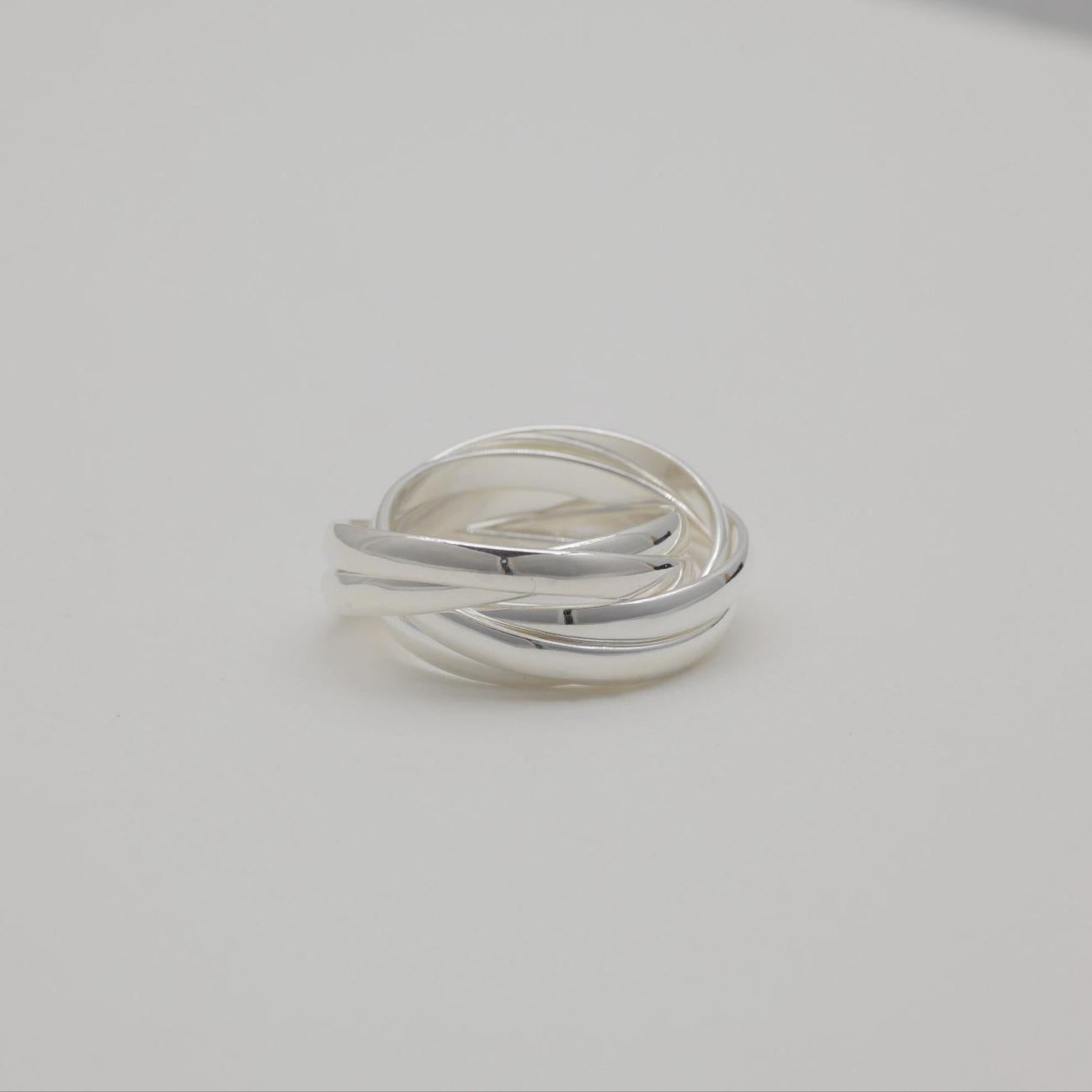Three interlocking polished sterling silver bands forming a trinity ring