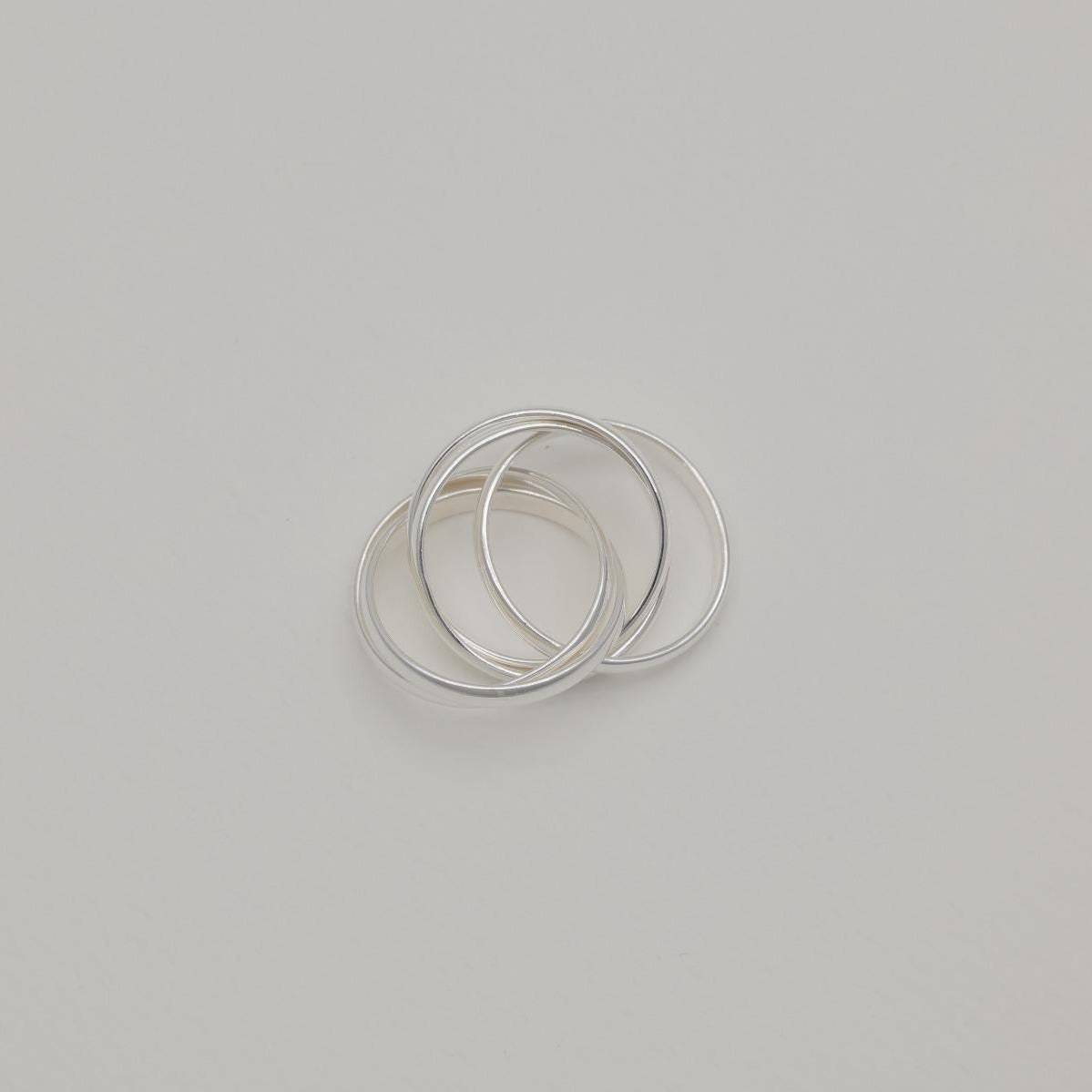Three interlocking polished sterling silver bands forming a trinity ring