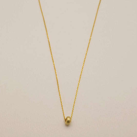 Full view of gold vermeil Noémie necklace with matte donut bead on silver chain

