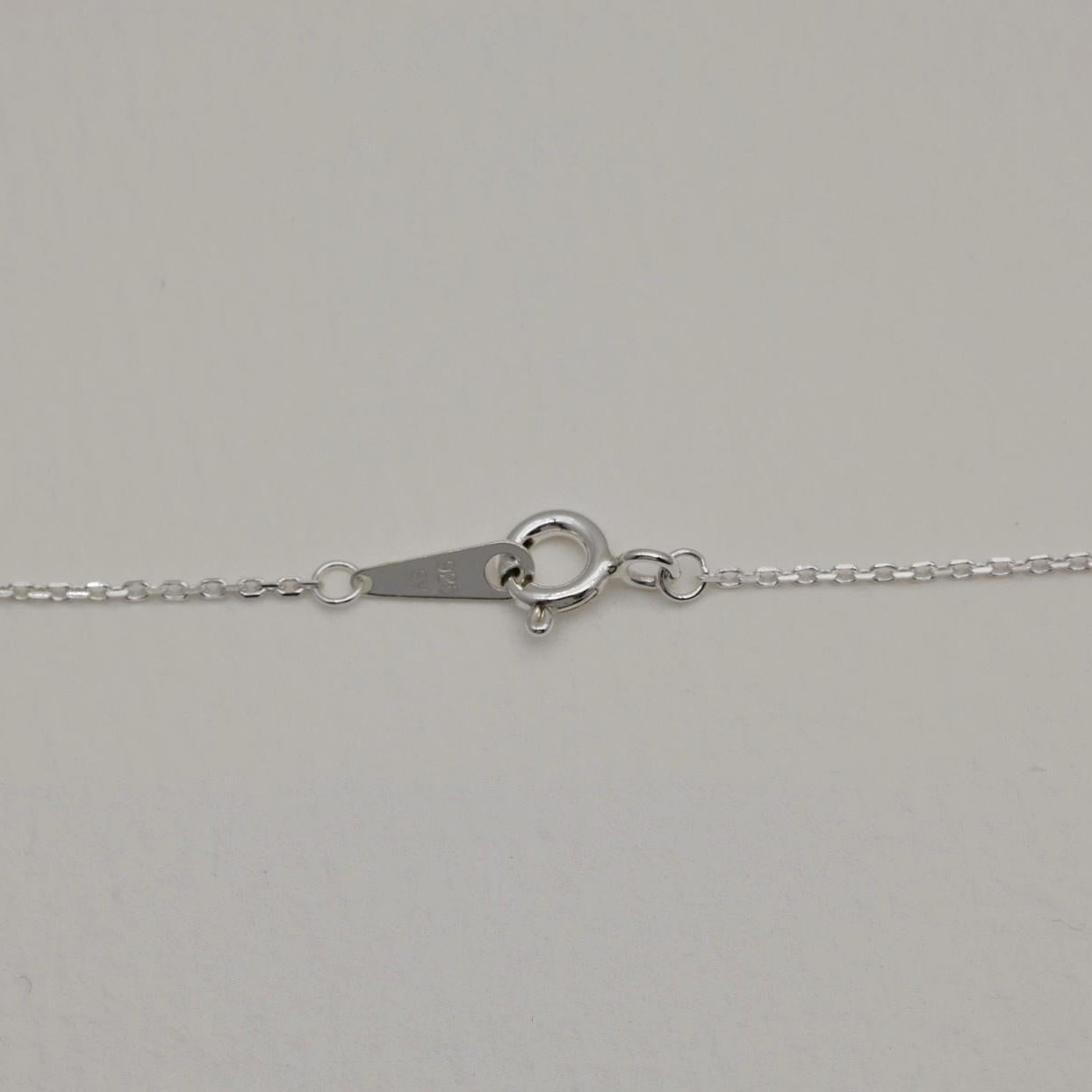 Detail of the silver clasp and extender on the Noémie Necklace with visible 925 hallmark.

