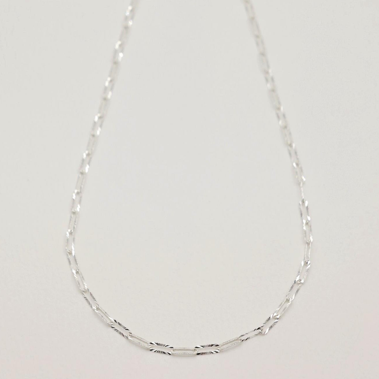 Full view of the Solène Necklace featuring radiant-cut rectangular links on a fine silver chain.