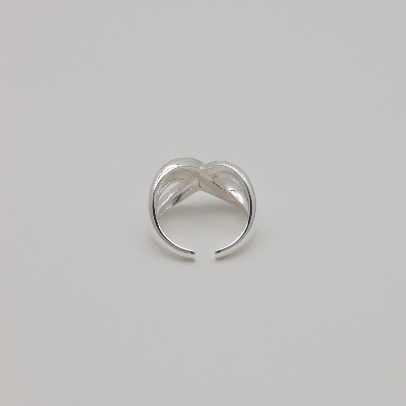 Axelle Crossover Ring in sterling silver with polished curved twist design and open adjustable band.