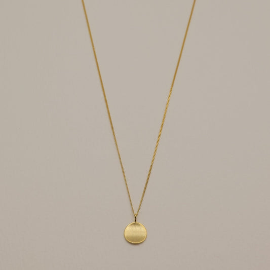  A full-view image of the Amélie Engravable Necklace in gold vermeil, featuring a round, plain pendant on a fine chain.