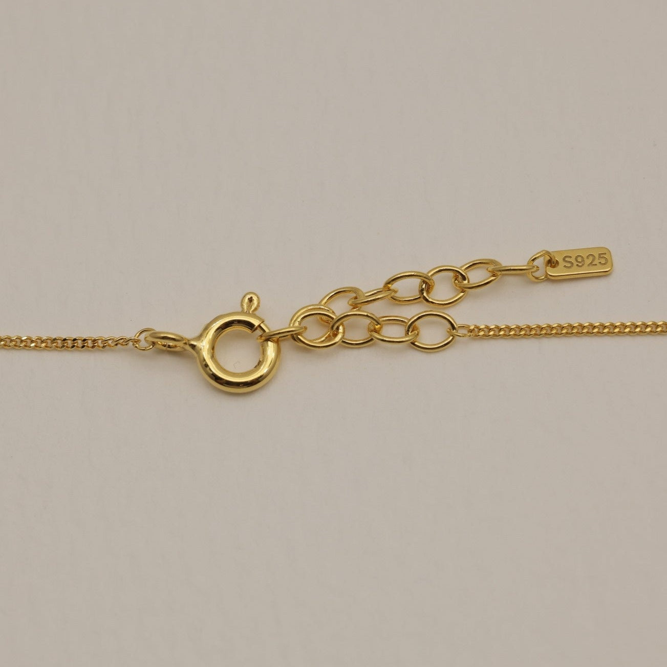 A detailed shot of the gold vermeil clasp and extender with an S925 tag.