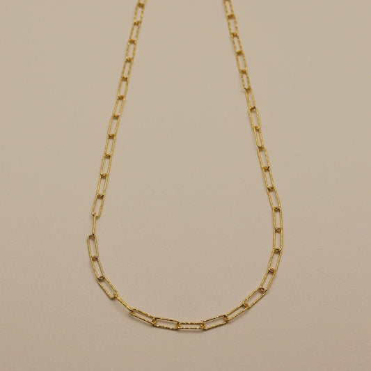 A gold vermeil textured chain necklace laid flat on a neutral background.