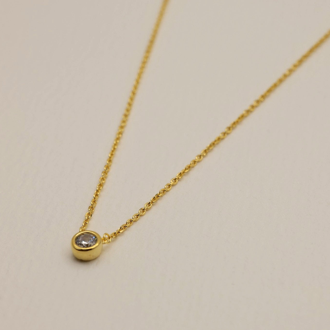 Close-up of gold vermeil pendant necklace with clear cubic zirconia detail