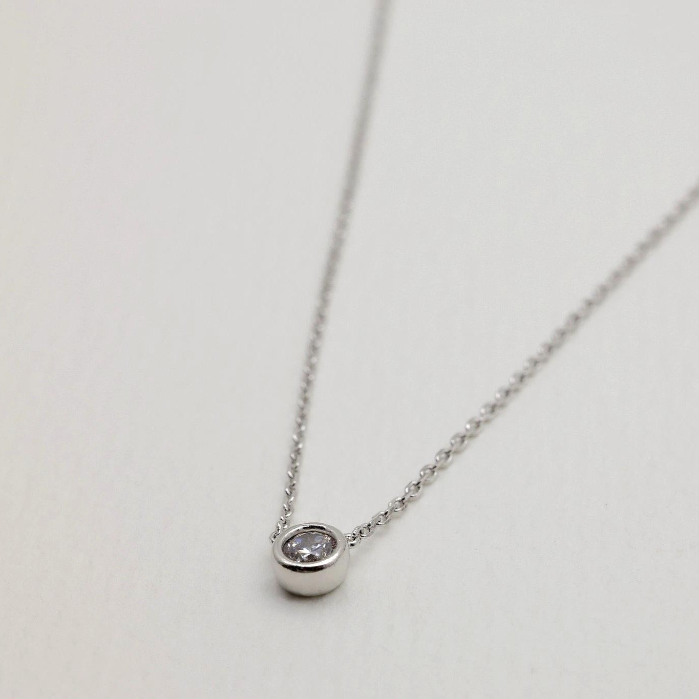 Elegant cubic zirconia pendant on a fine 925 silver chain, displayed in a soft-focused close-up angle.