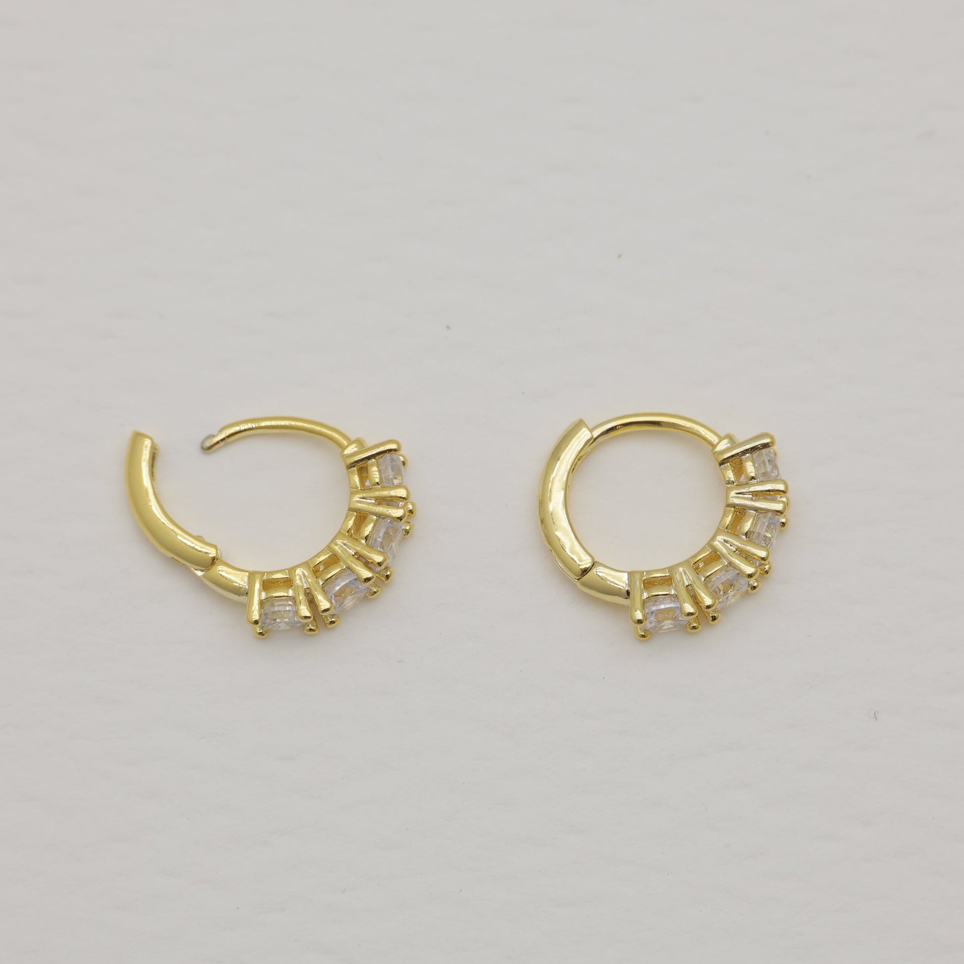 Pair of gold hoop earrings on a light gray background