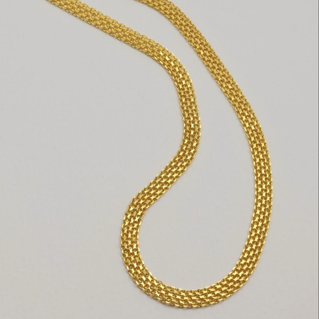Wide angle of necklace showing shine and fluid drape.