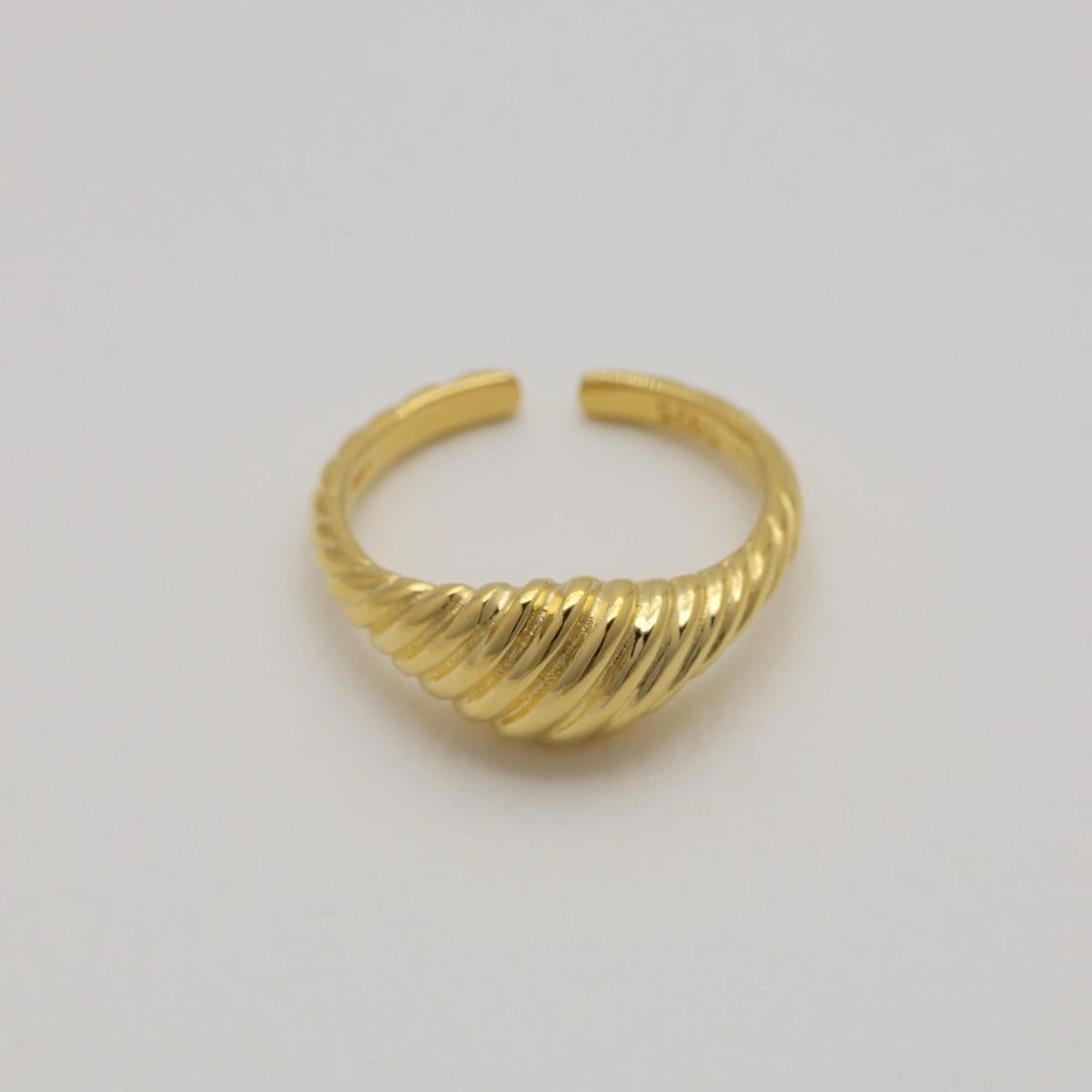 Close-up of the Odile Ring showing its structured silhouette and golden glow.

