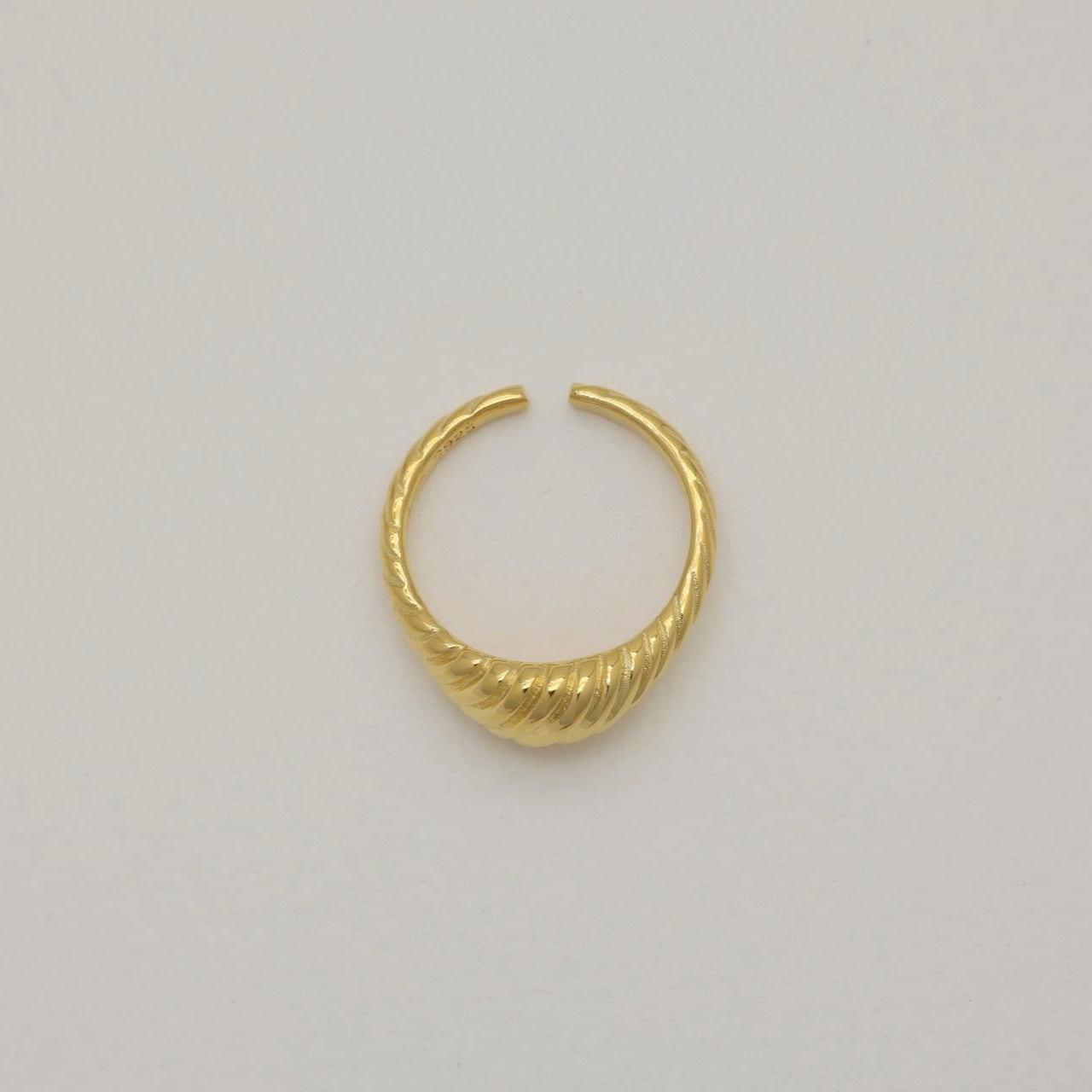 Overhead view of the Odile Ring in gold vermeil on a cream background, showing its sculptural ridged dome.