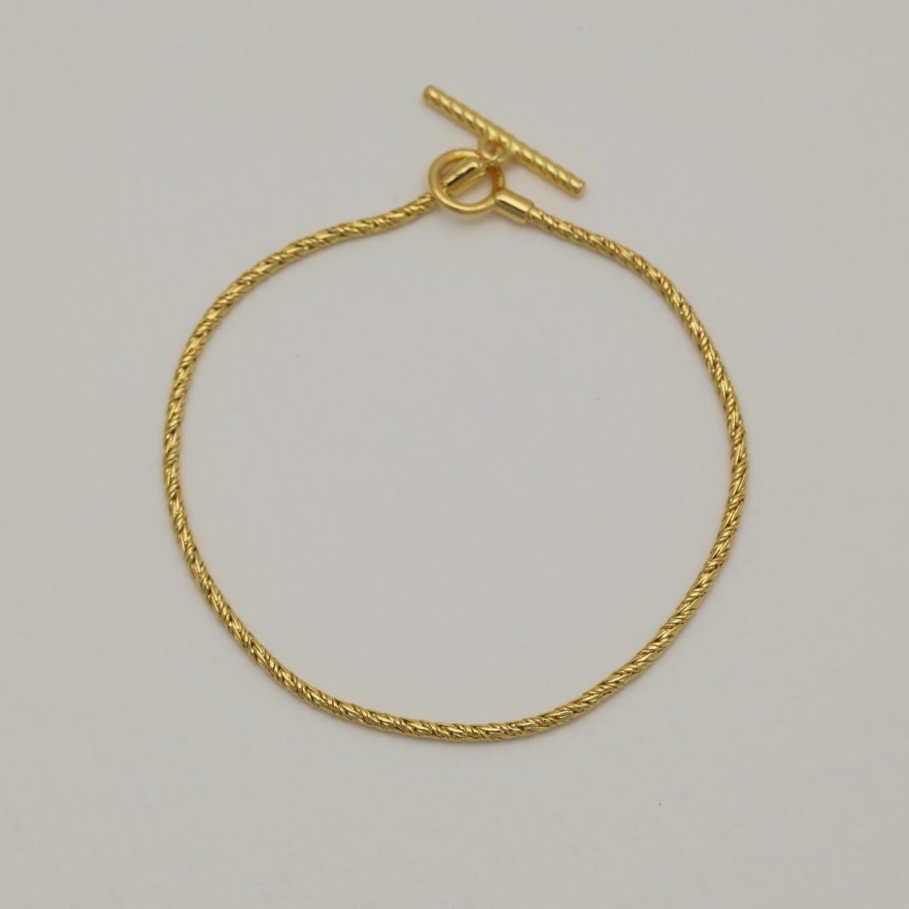 Full view of the Érine Bracelet in gold vermeil, laid flat in a circle against a neutral background.