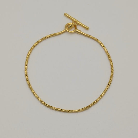 Full view of the Érine Bracelet in gold vermeil, laid flat in a circle against a neutral background.