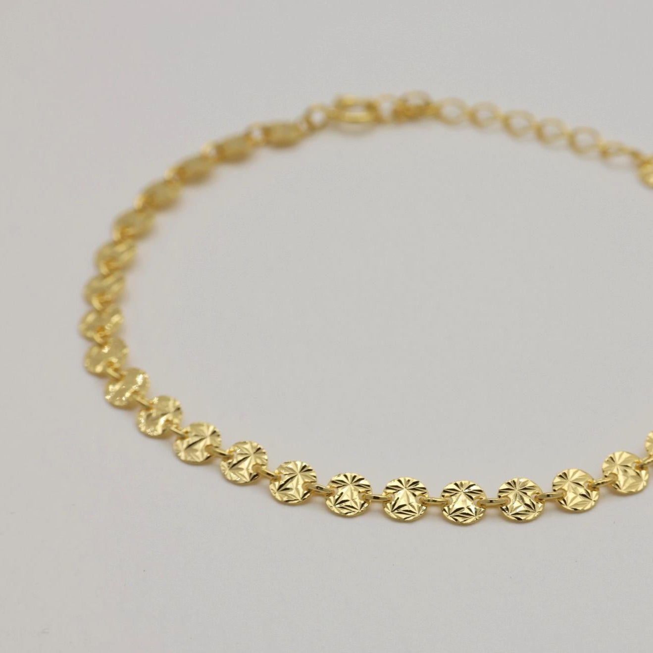 Angled close-up of the faceted round links catching light.

