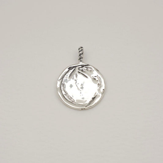 Silver pendant with a clear gemstone on a light gray background