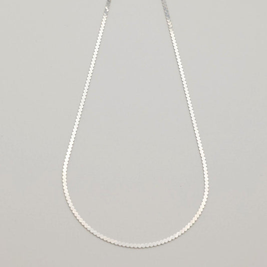 A sterling silver flat chain necklace with bold interlinked discs and a polished finish, shown in close-up and full length on a neutral background.