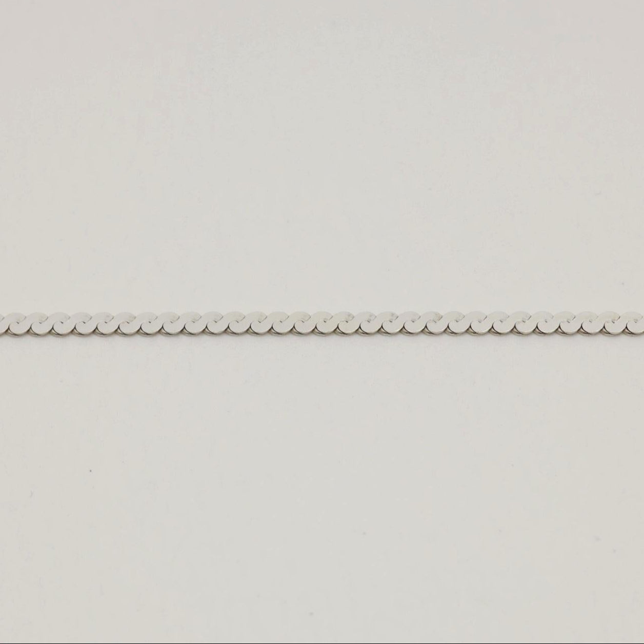 A sterling silver flat chain necklace with bold interlinked discs and a polished finish, shown in close-up and full length on a neutral background.
