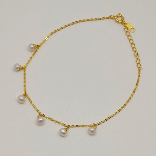 Gold vermeil chain bracelet with six small natural pearl drops, displayed on a neutral background.