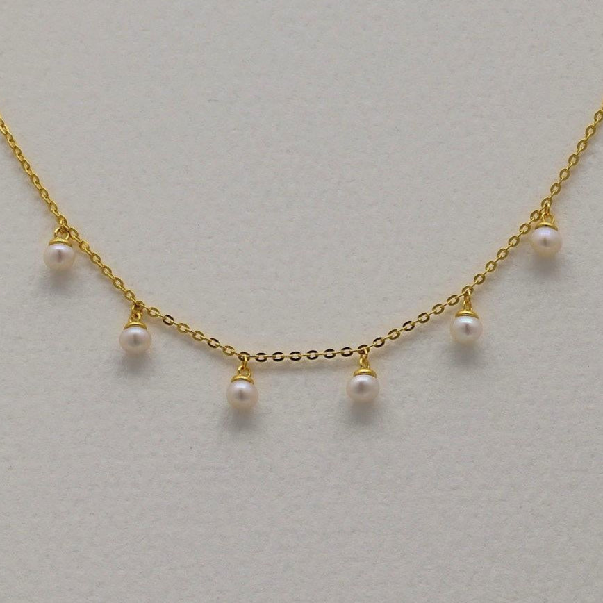 Gold vermeil chain bracelet with six small natural pearl drops, displayed on a neutral background.