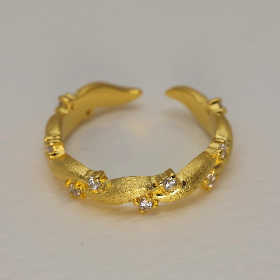Gold vermeil pavé ring with matte finish and cubic zirconia, adjustable band shown against a white background