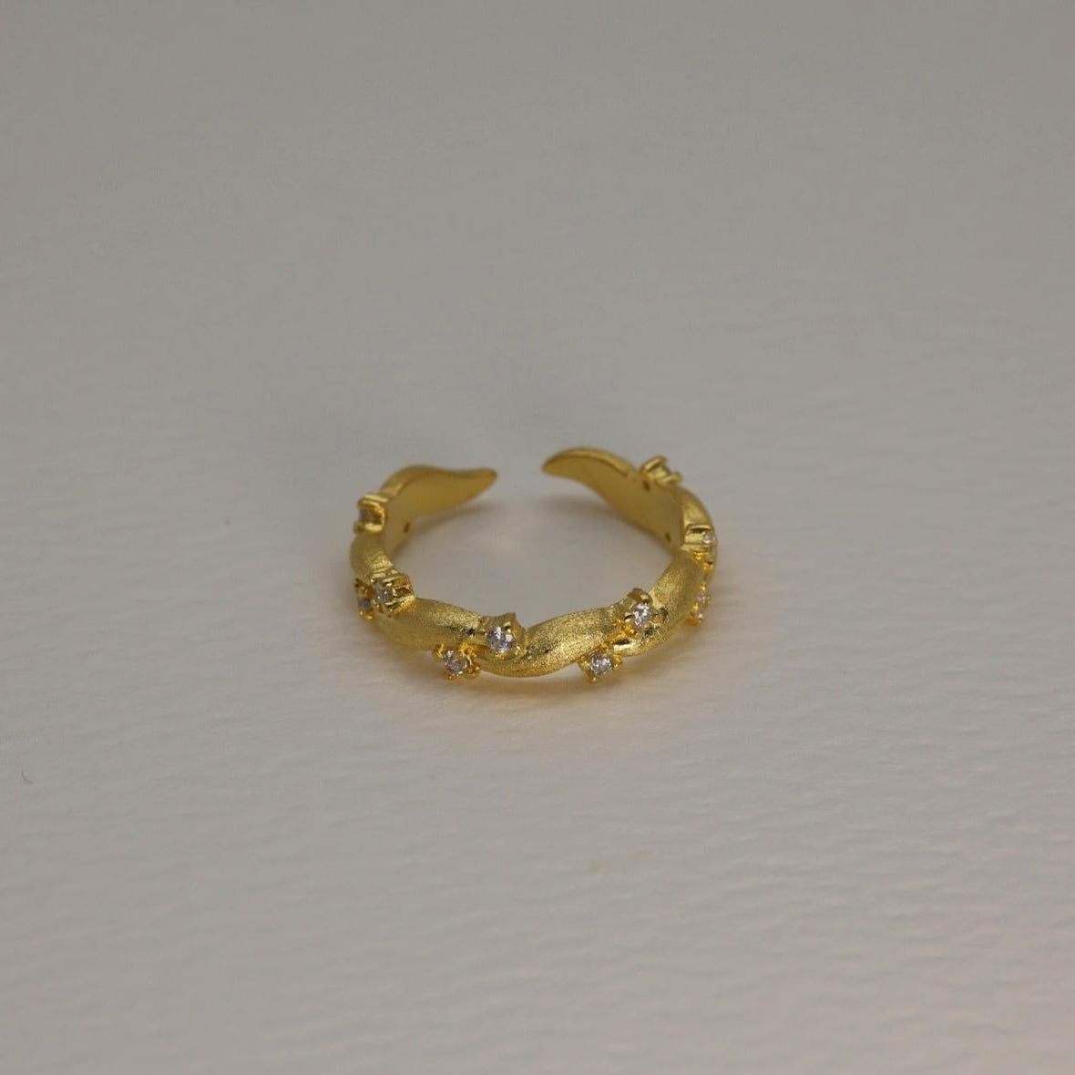 Gold vermeil pavé ring with matte finish and cubic zirconia, adjustable band shown against a white background