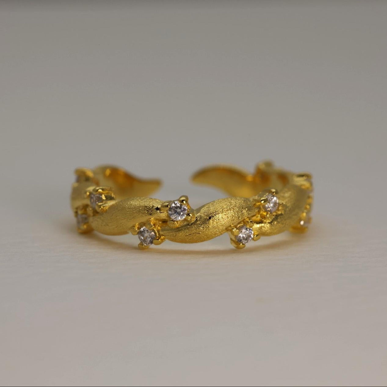 Gold vermeil pavé ring with matte finish and cubic zirconia, adjustable band shown against a white background