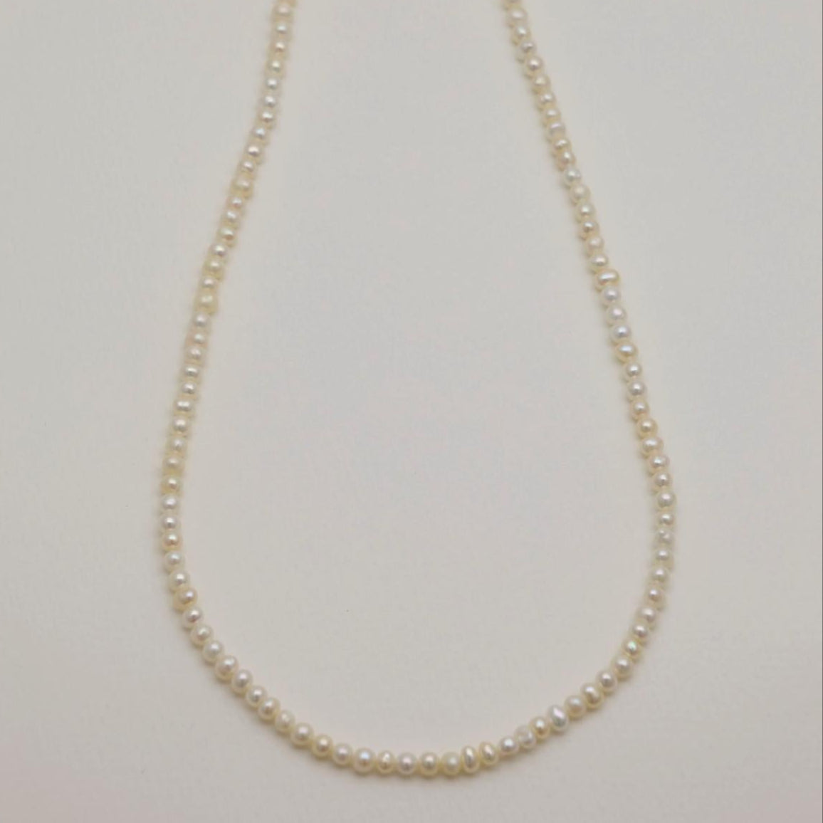 Pearl necklace on a light gray background