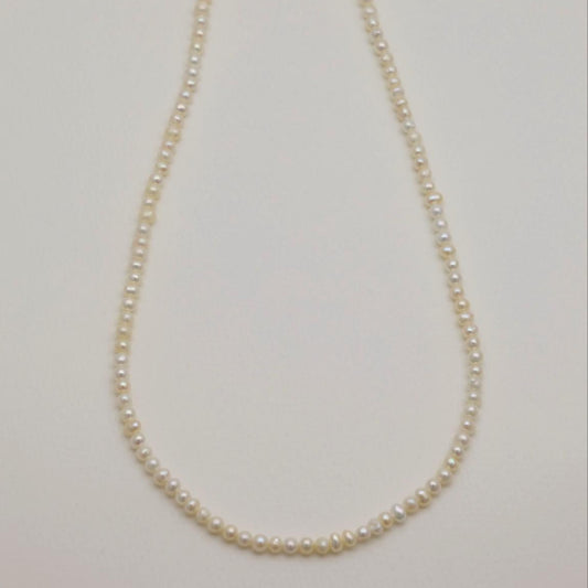 Pearl necklace on a light gray background