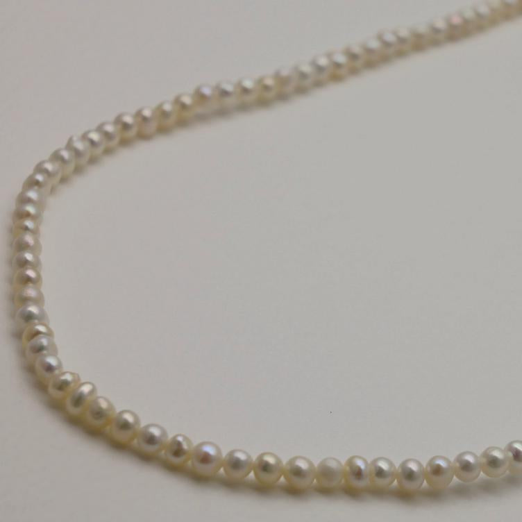 Pearl necklace on a light gray background