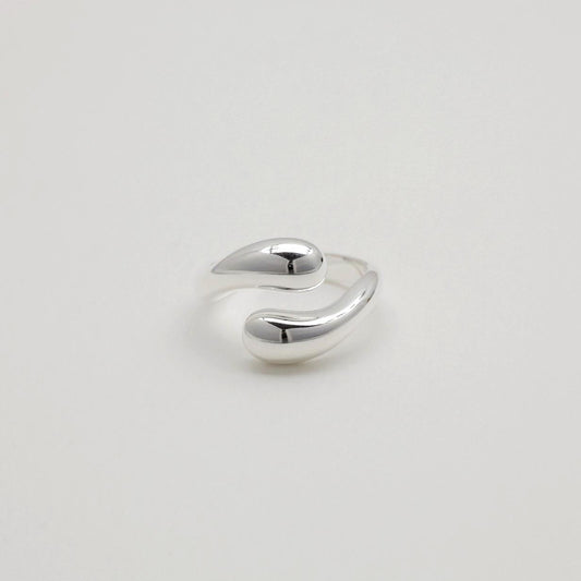 Sculptural sterling silver ring with teardrop-like ends and a polished adjustable wrap design.