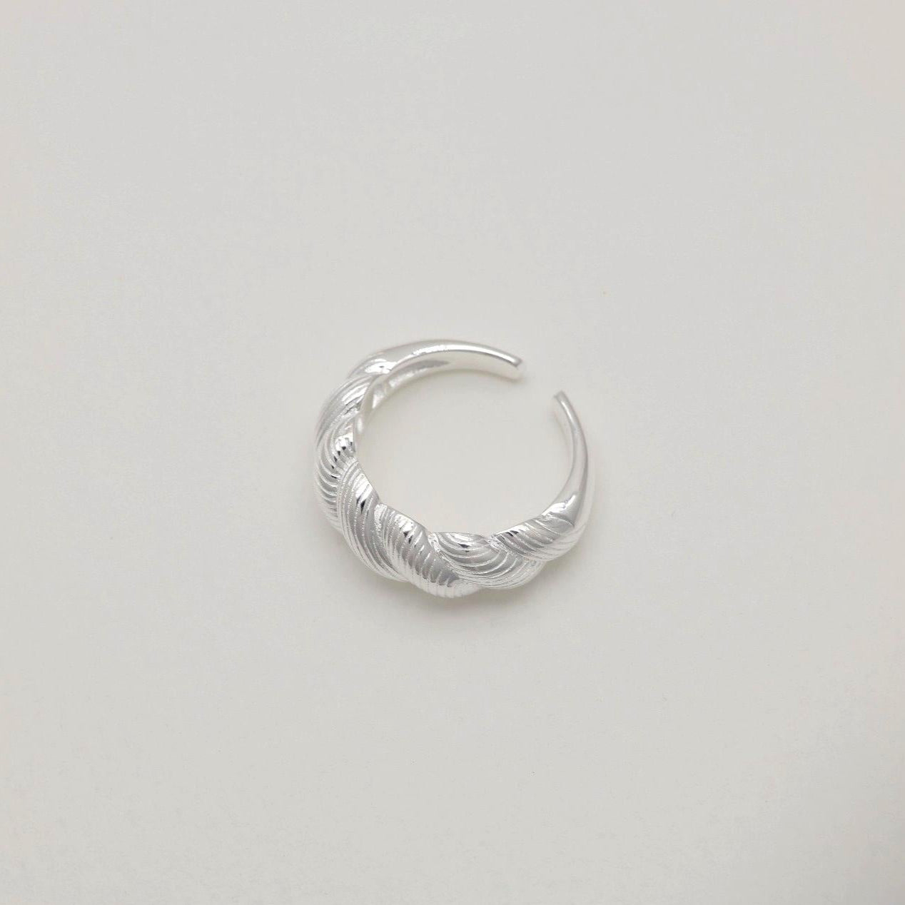 Top-down shot of a polished braided ring in 925 sterling silver, showcasing open back