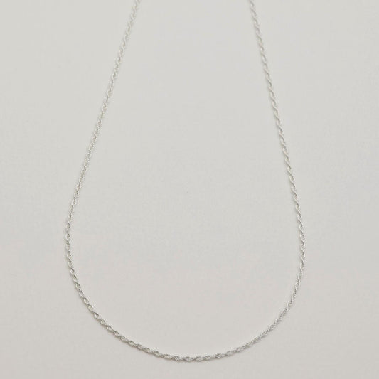 A sterling silver rope chain necklace with fine twisted links, displayed on a light neutral background. 42cm length, polished finish